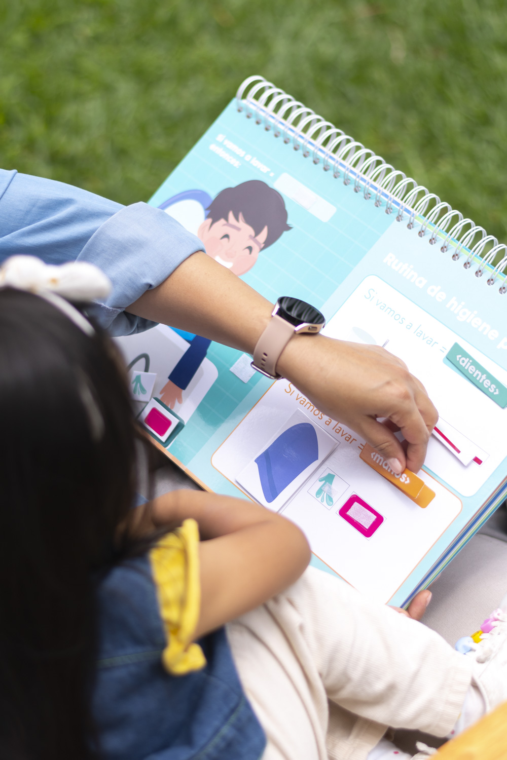 Mamá y niña jugando con el libro Jugando a Programar con piezas de velcro para aprender lógica sin pantallas